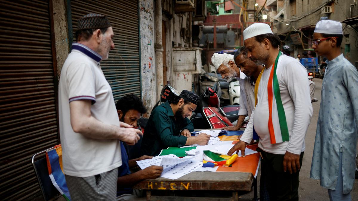 People check their names in the voters list outside a polling station on the day of the sixth phase of the general election in the old quarters of Delhi, India, May 25, 2024.